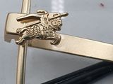 a gold tie bar with a rabbit on it