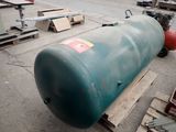 a large green tank sitting on a pallet in a warehouse