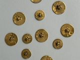 several gold buttons are arranged in a circle on a white surface