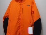 une veste orange et noire accrochée à un mur blanc