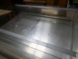a metal counter top in a kitchen with a glass door
