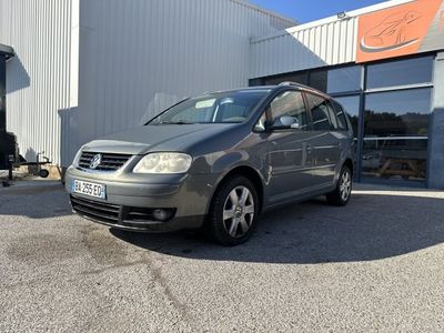 La voiture est garée devant l'immeuble, sur le parking.