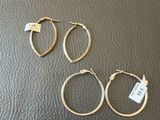 three pairs of gold hoop earrings on a black leather surface