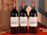 three bottles of wine sitting on a table next to a wooden crate