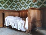 un lit dans un coin d'une pièce dont l'un des murs est tapissé