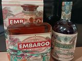 une bouteille d'Embargo à côté d'une caisse d'alcool