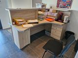 a corner desk with a chair in the corner of the room