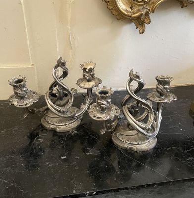 un groupe de bougies argentées posées sur une table noire