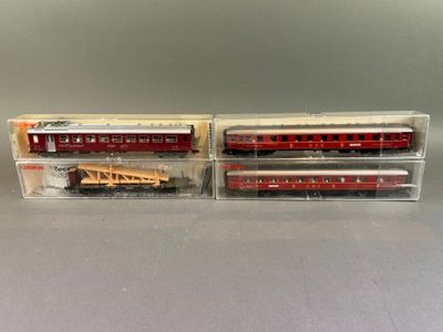 deux trains miniatures rouges et blancs dans des boîtes transparentes posés sur une table