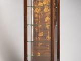 an antique wooden display case with a glass door and flowers
