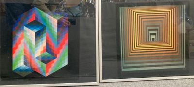 two different colored paintings in a glass case on the wall