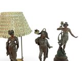 three bronze figurines of women with lamps and a lamp shade