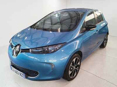 La voiture bleue est garée dans une pièce blanche au sol blanc.