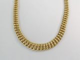 gros plan d'un collier à chaîne en or sur une surface blanche