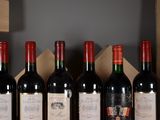 several bottles of red wine are lined up on a shelf