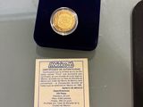 a gold coin sitting on a table next to a black box