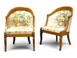 pair of chairs with floral upholstered cushions and wooden legs