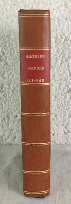 an old book sitting on top of a table next to a white wall