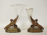 une paire de vases anciens en bronze et en verre posés sur une table
