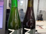 two bottles of beer sitting next to each other on a desk