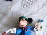 une figurine de Mickey Mouse et un chat sur un lit