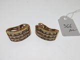 pair of gold tone earrings with white stones and a price tag