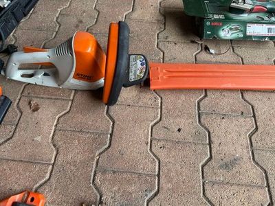 un souffleur filaire et d'autres outils posés par terre