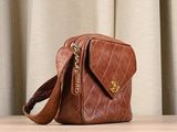 a brown purse sitting on a table with curtains in the background