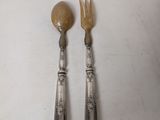 two spoons and a fork on a white table