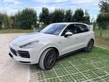 Une Porsche Cayenne blanche est garée sur un parking
