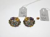 two pairs of earrings and a price tag on a white surface