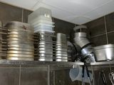 pots and pans are stacked on a shelf in a kitchen
