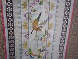 an image of a table runner with a bird and flowers on it
