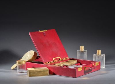 une valise rouge contenant de nombreuses bouteilles de parfum
