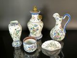 five different vases and cups on a black table