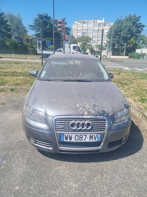 une voiture sale garée sur le bord de la route