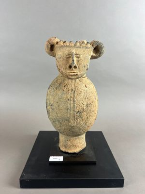 une photo d'une sculpture en pierre représentant une tête posée sur un socle noir