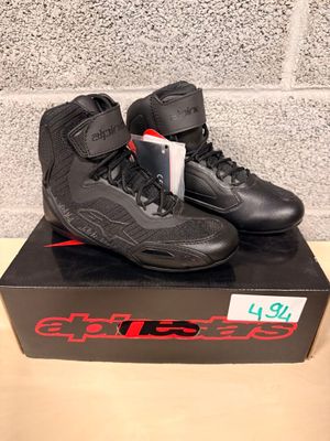 black and red shoes on a box on a table in front of a brick wall