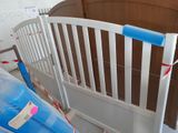 a baby crib that has been painted white and has a blue tape on it