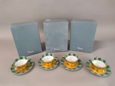 Quatre tasses à thé et leurs soucoupes sont posées sur une table.