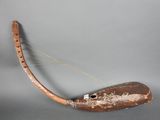 une longue corne munie d'un manche en bois, posée sur une table