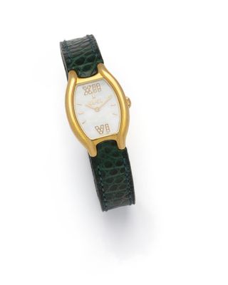 a close up of a watch on a white surface with a green strap