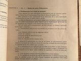 un livre ouvert sur une table sur laquelle se trouvent plusieurs feuilles de papier