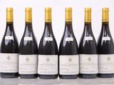 six bouteilles de vin sont alignées sur une table