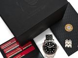 une boîte noire sur laquelle se trouvent une montre, un portefeuille et d'autres objets