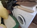 a stack of pillows on top of a washing machine