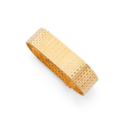 gros plan d'un bracelet en or sur fond blanc