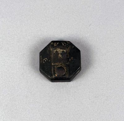 a close up of a small metal object on a white surface