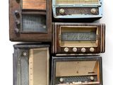 plusieurs radios à l'ancienne empilées les unes sur les autres sur une surface blanche