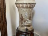 un vase blanc posé sur un socle en bois dans une pièce
